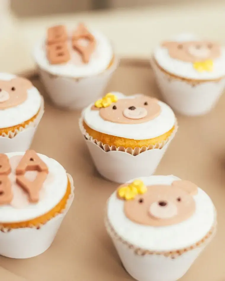 Cupcakes decorados con caras de osito y letras de la palabra baby